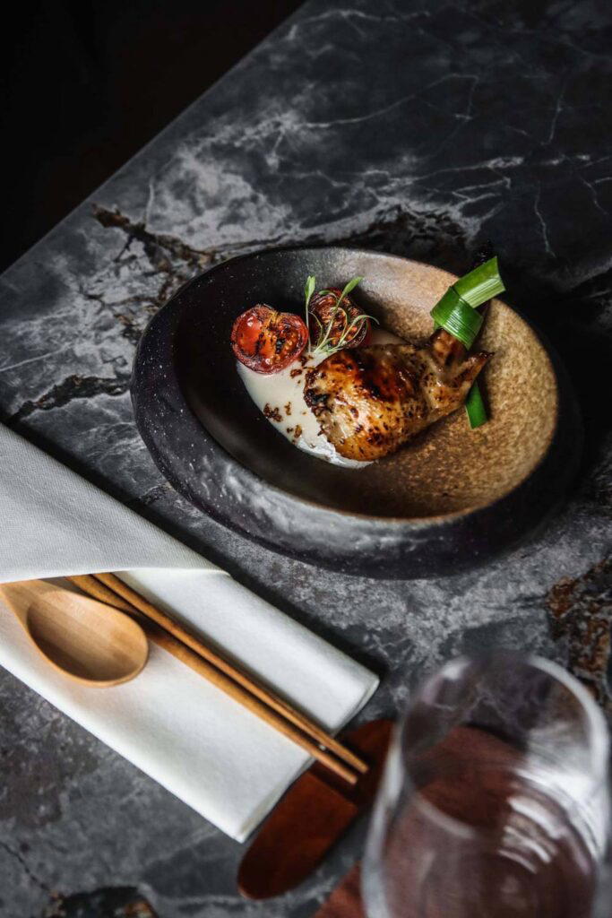 Tom Kha Gai, or baked chicken wing with stuffed mushroom rice and tom kha sauce (Credit: Chedi)