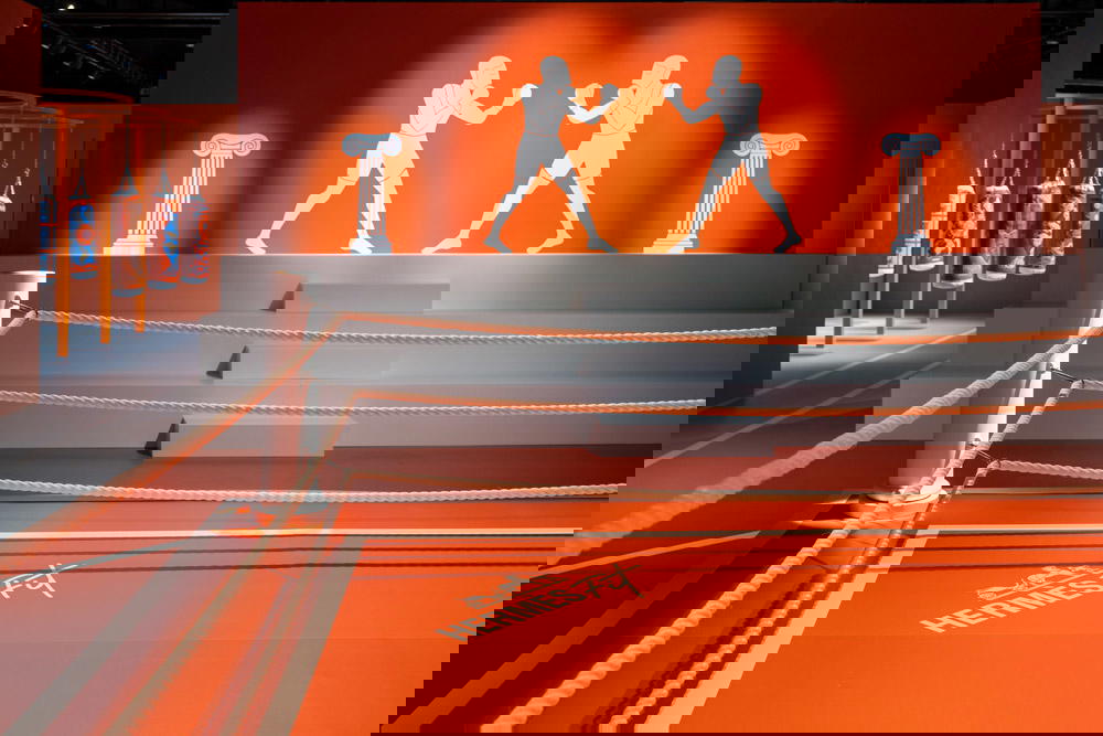 A boxing ring dressed in Hermès orange that transforms into a stage in the evenings