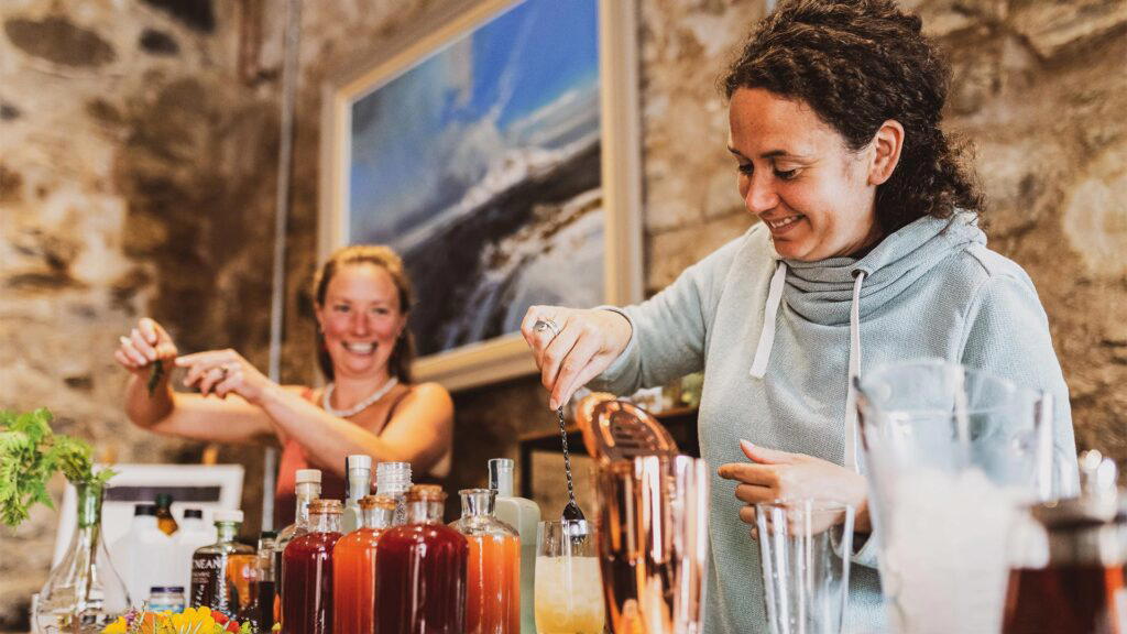 Several women making foraged cocktails