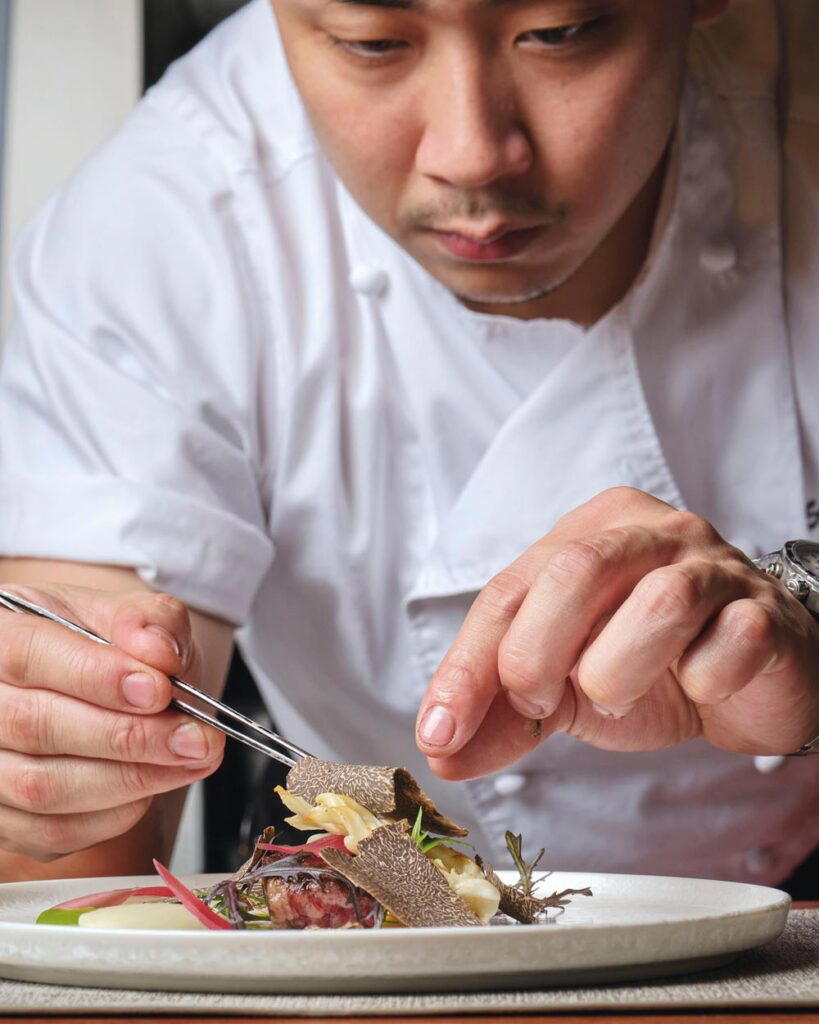 A chef at Artifact puts the finishing touches