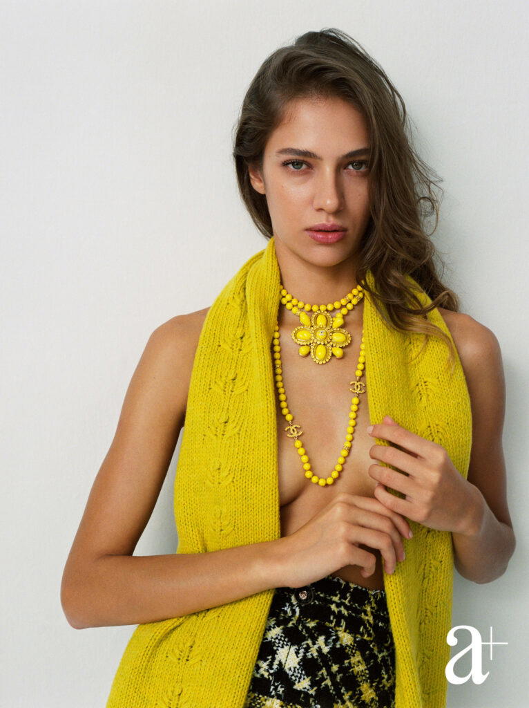 Wool scarf, embellished fantasy tweed skirt and metal necklaces with glass beads, rhinestone and resin, all from Chanel