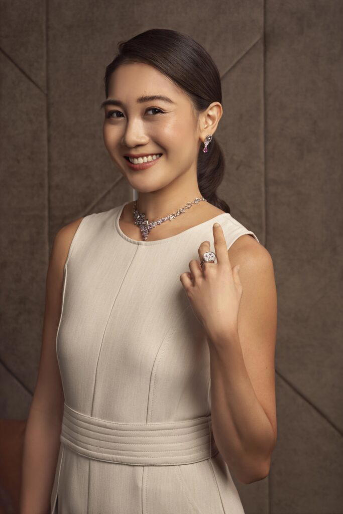 See wears earrings in white gold with pink sapphires and diamonds, a necklace in white gold with pink sapphires and diamonds, and a Lotus ring with sapphires and diamonds (Credit: UltraLuxe)