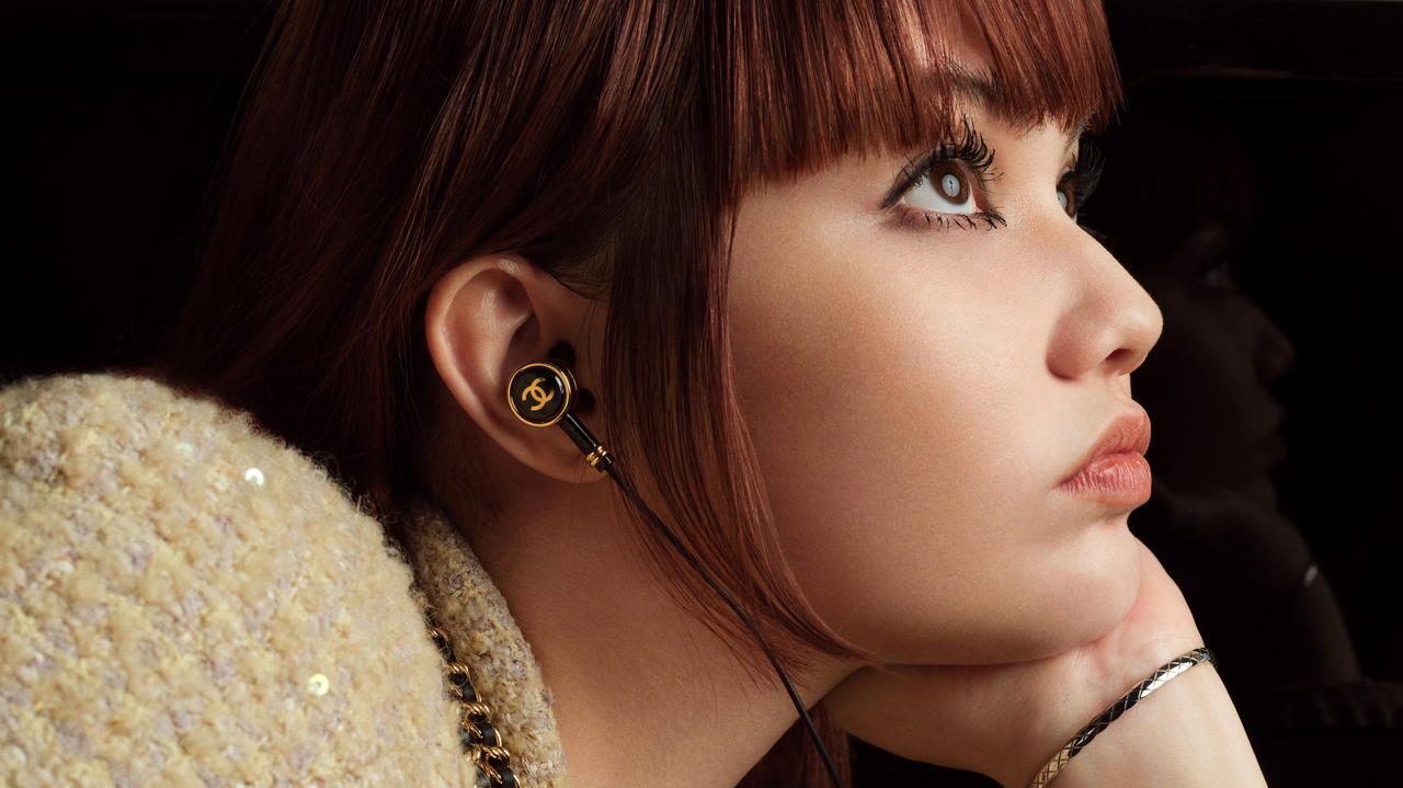 Shye wears Première sound watch in steel coated with yellow gold with steel headphones, Coco Crush bracelet in white gold; sequinned fantasy tweed jacket with matching top and skirt, and calfskin boots, all from Chanel