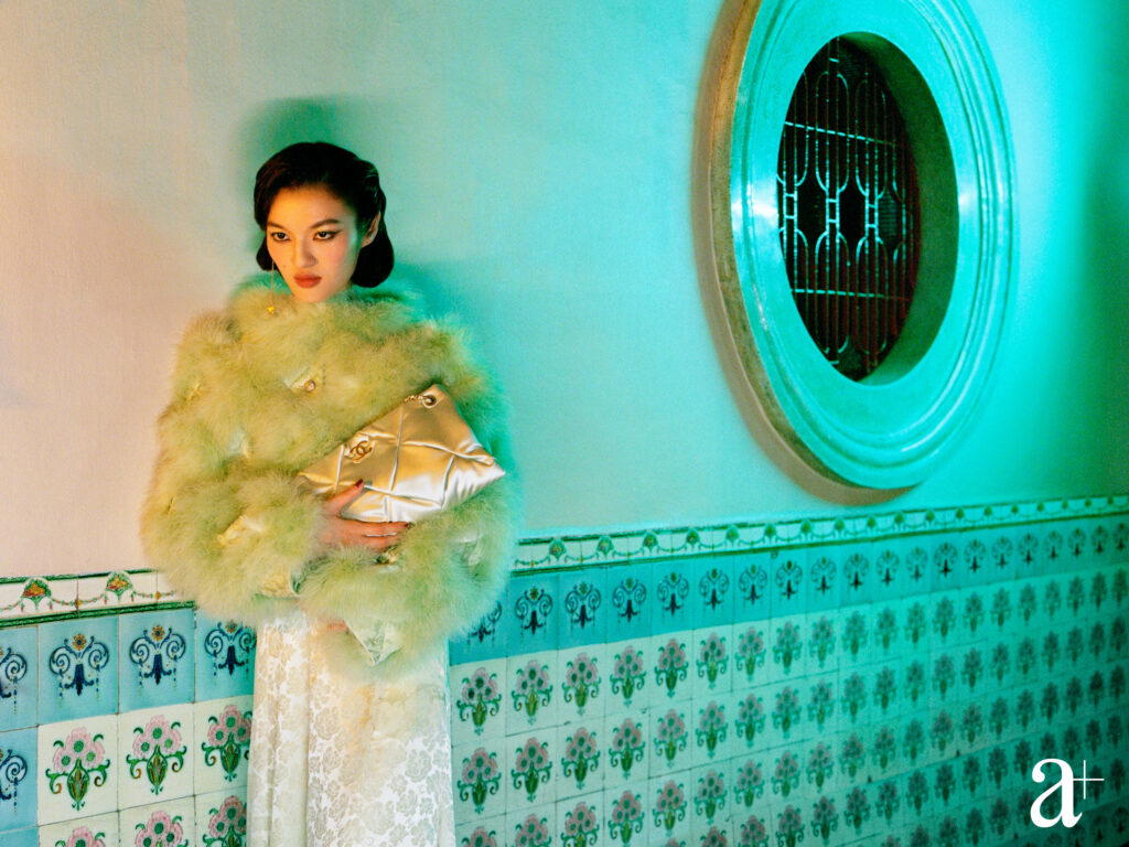Pleated silk charmeuse blouson with feathers and jewelled buttons, embroidered silk jacquard dress, silksatin bag, and metal and &nbsp;strass earrings,&nbsp;from Chanel (Photography: Stefan Khoo)