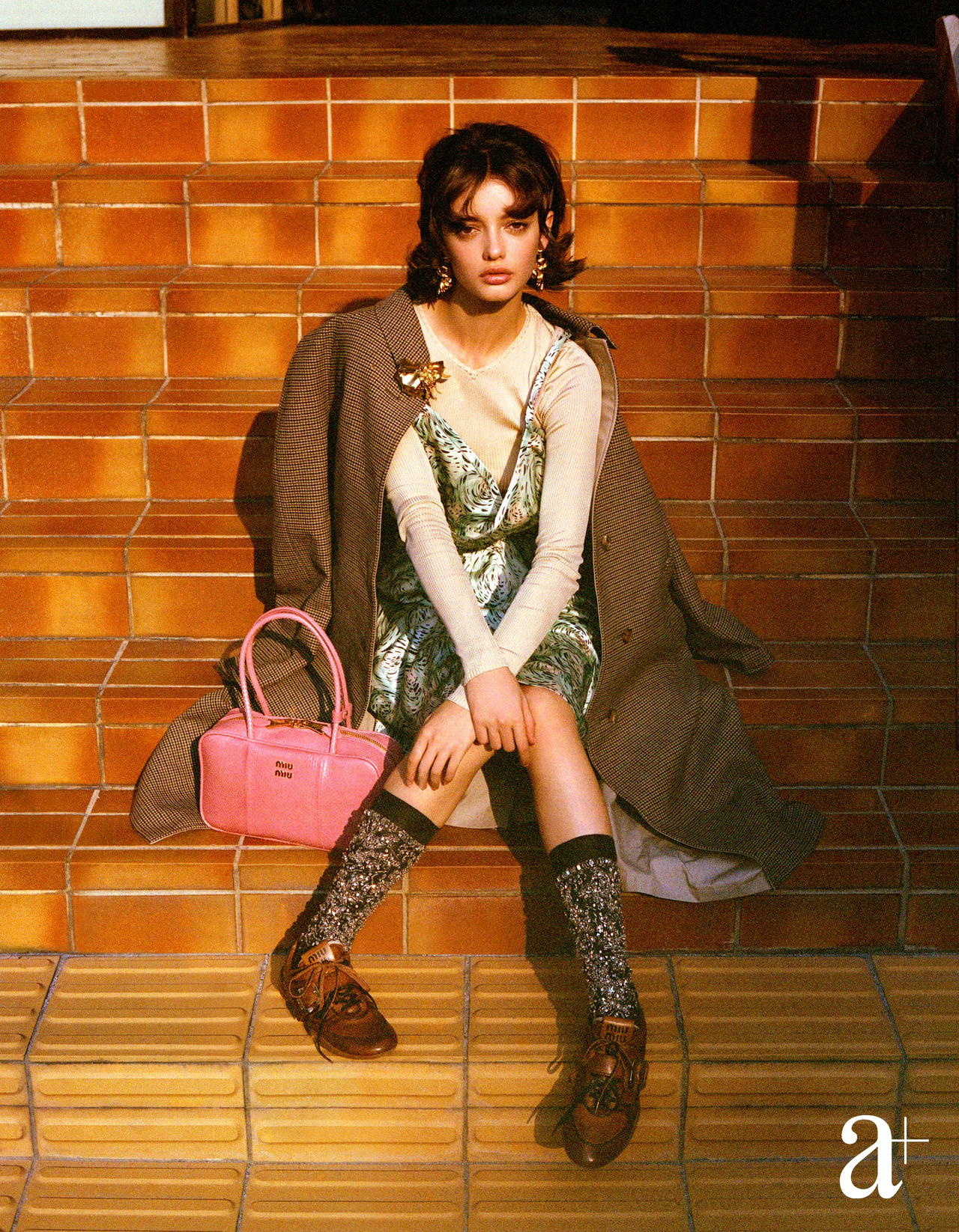 Silk sweater, silk satin dress, wool and cotton trench coat, brass earrings and brooch, Ayers water snakeskin Beau bag, crystal embellished silk socks, and calfskin buckle sneakers, all from Miu Miu (Credit: Stefan Khoo )