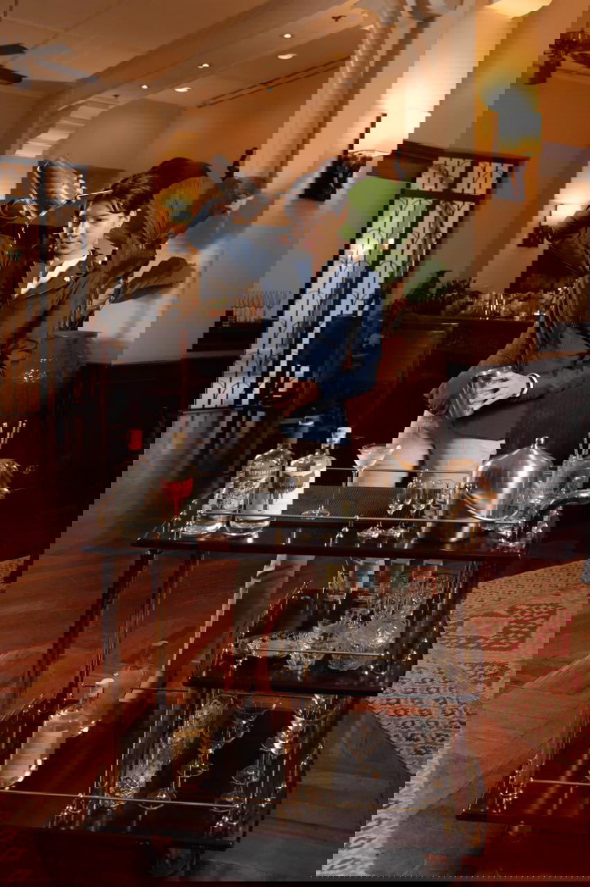 Gin Butler Nisha mixes up cocktails from a vintage-style trolley using gins from Cambodia (Credit: Raffles)