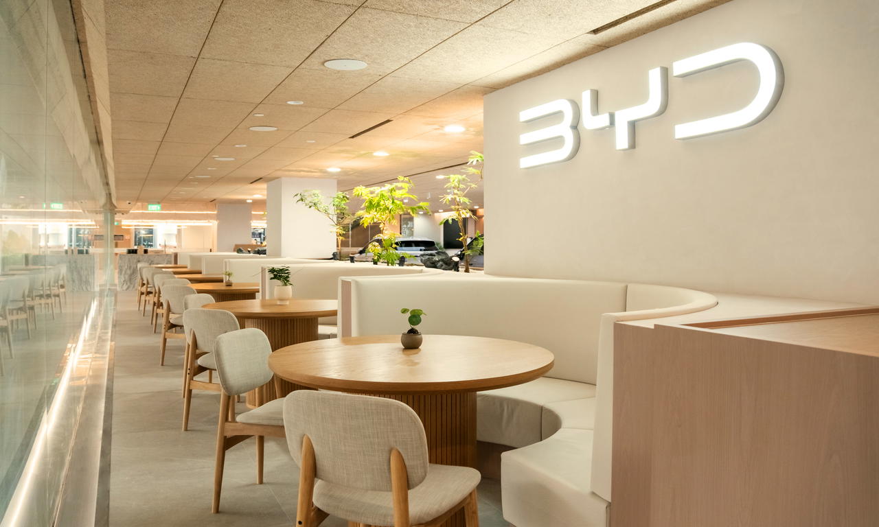 Stone surfaces, light wood finishes, woven accents, and greenery soften the look of the space