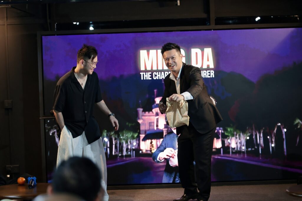 Magician Ming Da (right), aka, The Charming Conjuror,&nbsp; enlists assistance from a member of the audience during the opening (Credit: Institute Illusions SG)