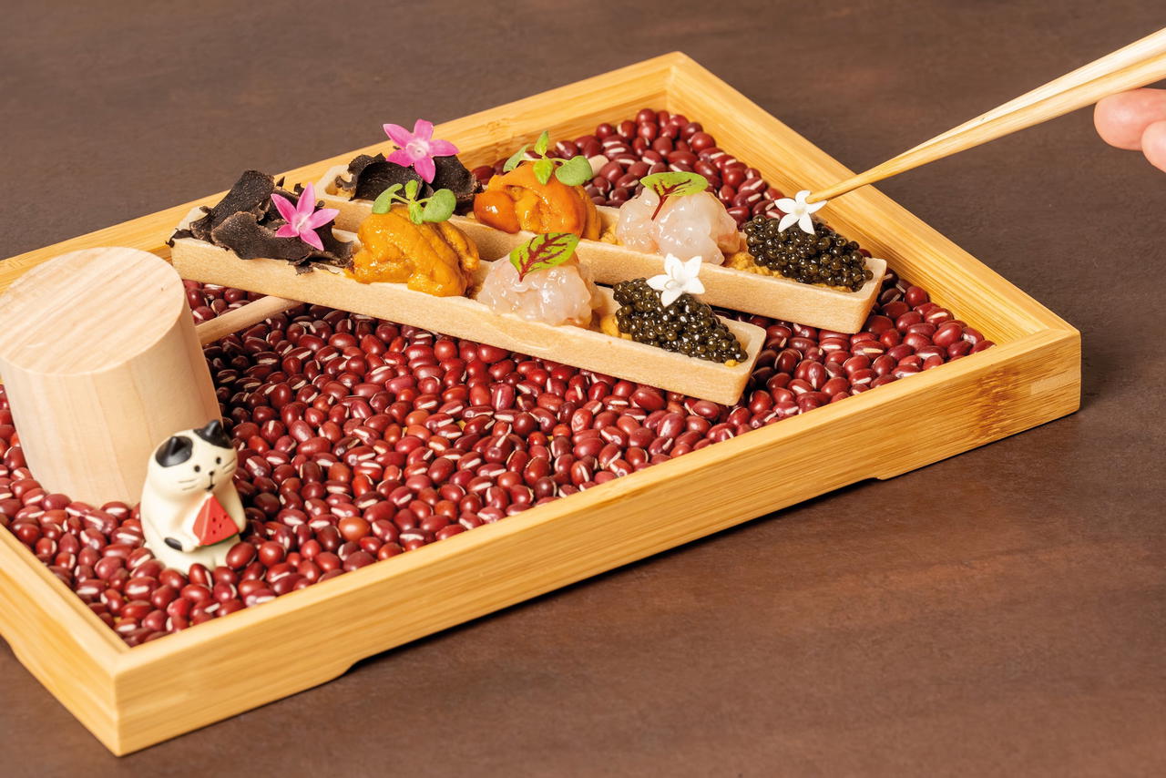 The decadent Monaka, presented alongside an adorable cat figurine, comes with caviar, botan ebi, uni, truffle, and ankimo (Credit: Jiin Omakase)